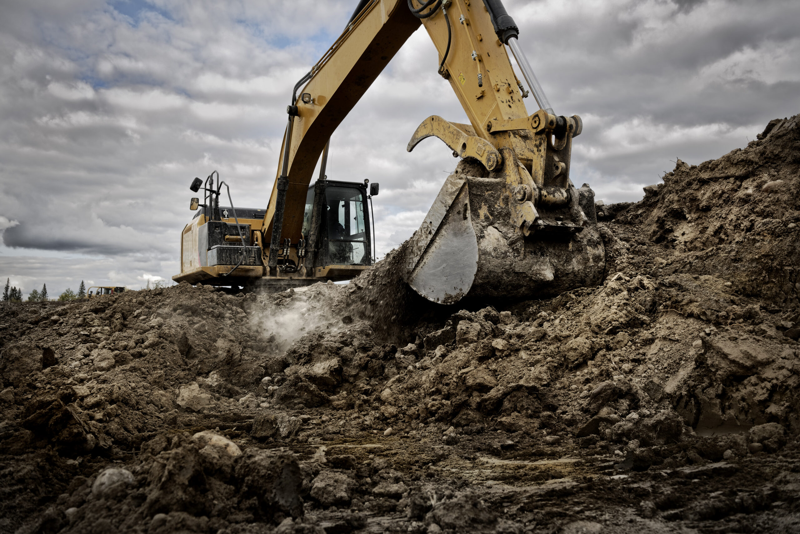 An excavator digging into the ground with its large bucket